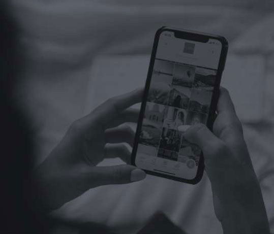 black and white image of someone holding a phone scrolling images