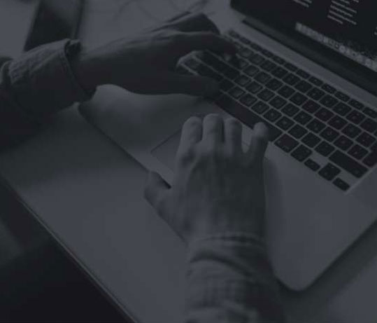 black and white image of someone typing on a laptop